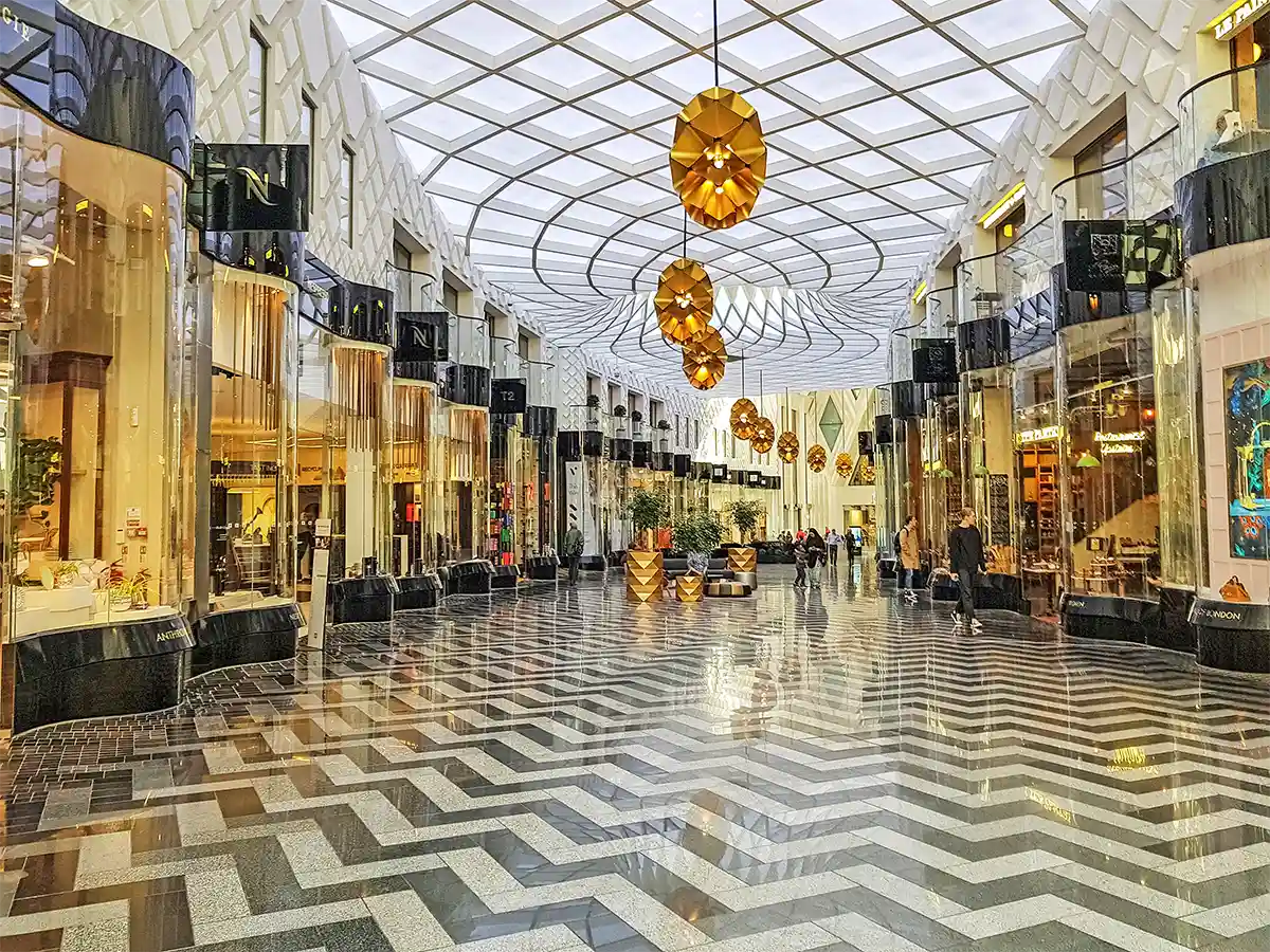 Modern shopping arcade in Leeds, West Yorkshire, featuring stylish boutiques, geometric flooring, and a unique ceiling design.